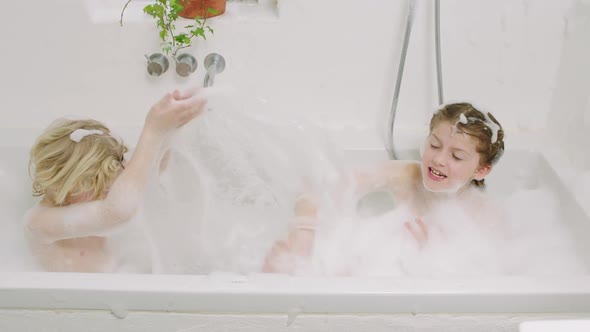 Kids Splashing Water And Soap Suds From Bath