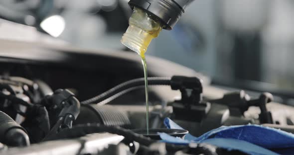 Close up shot of the oil canister. Car Service Worker Changes Oil In The Car