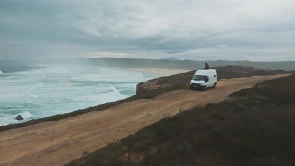 Landscape of wild ocean coast with waves and a van shot by drone