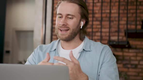 A Man Communicates Friendly Via Video Link with Wireless Headphones