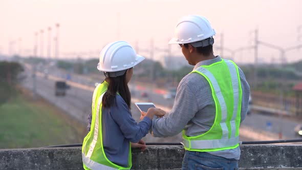 Two civil Engineering working with tablet on bridge highway