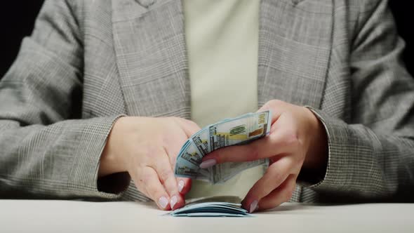 Counting American Hundred Dollar Banknotes on Black Background