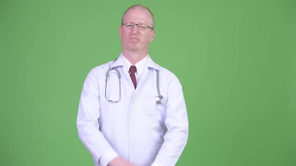 Mature Bald Man Doctor Showing Stop Gesture with Both Arms