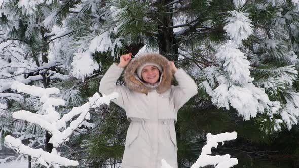 A Woman Jumps and Has Fun in the Winter Snowy Forest Snowflakes Fly By Slow Motion