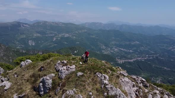 Hiker on top of mountain peak, European Alps, Lecco, Italy
