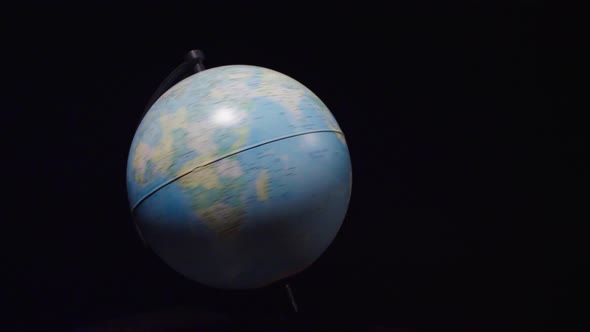 The globe rotates on a black background. Globe spinning on black screen. Slow motion	