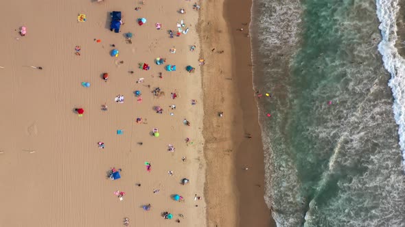 Bird's Eye View Of Crowded Beach During Summer Holiday - drone shot
