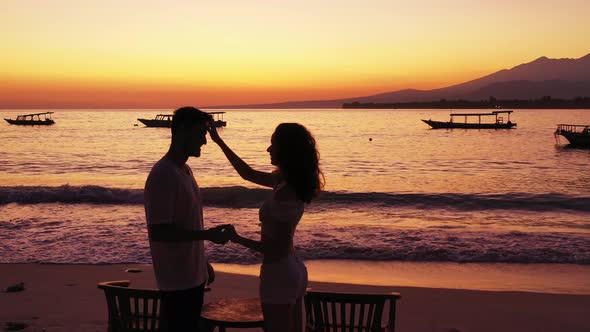 Young couple on romantic honeymoon enjoy life on beach on summer white sandy 4K background