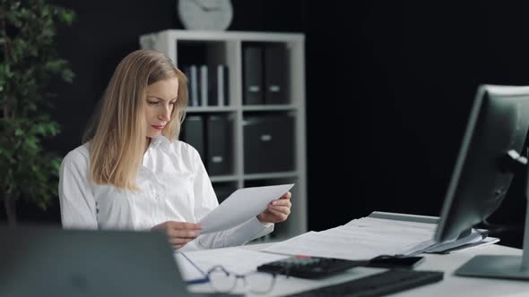 Businesswoman Reading Documnets at Office