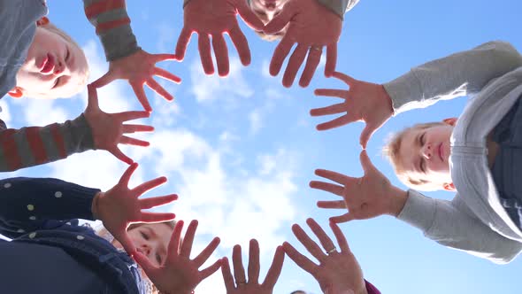 A Friendly Large Family Makes a Circle Shape Out of the Palms of Their Hands. alt