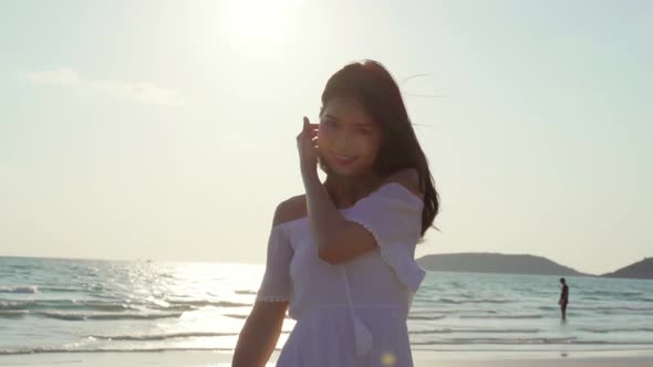 Beautiful female happy relax walking on beach near sea when sunset in evening.