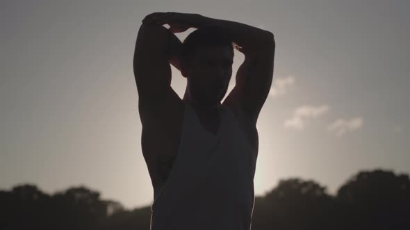 Man Stretches Before He Works Out Whilst Being Silhouetted By The Evening Sun In Slow Motion  - Ungr