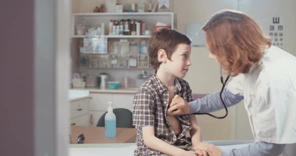 Female doctor examining a young boy in a clinic