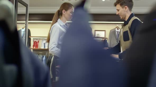 Man with Jacket Chatting at Cash Register