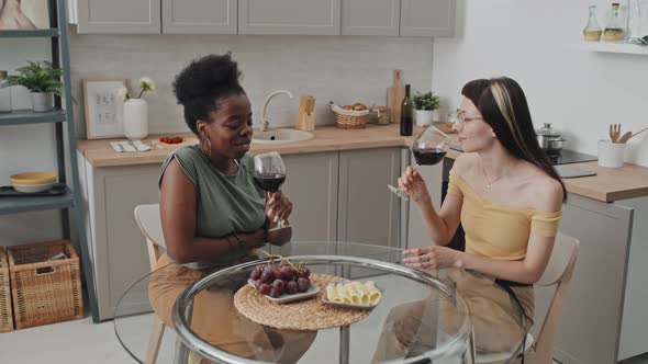 Lesbian Couple Drinking Wine in Kitchen