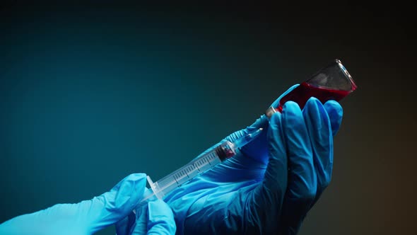 Doctor Filling Syringe with Red Solution