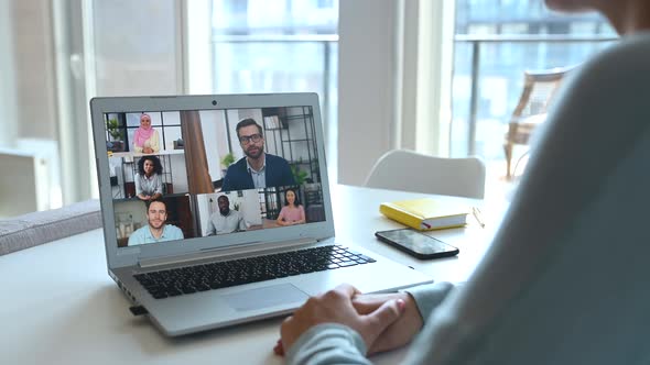 Young Woman Using Laptop for Video Meeting with Group of Diverse People