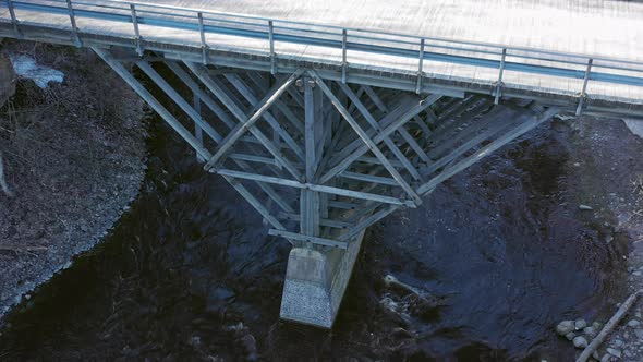 Beautiful Drone Point of View of a River Flowing Under a Wooden Bridge