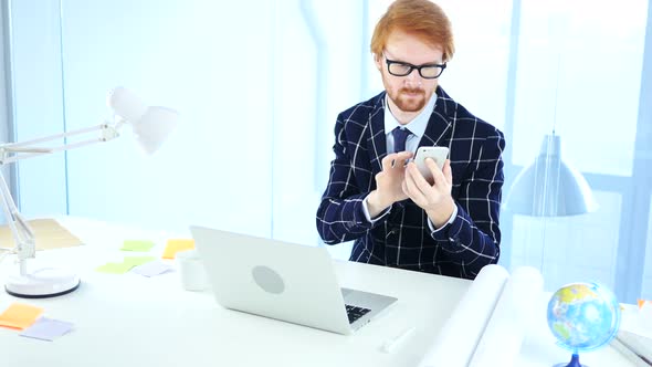 Redhead Man Using Smartphone for Online Browsing, Designer