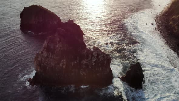 Aerial View of Ocean Waves Crashing Into the Seaside at Sunrise