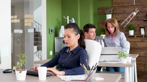 Confident Young Business Woman Sitting at Her Office and Working Hard