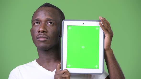 Young African Man Thinking While Showing Digital Tablet