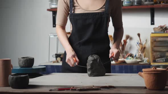 Woman using wire cut with clay