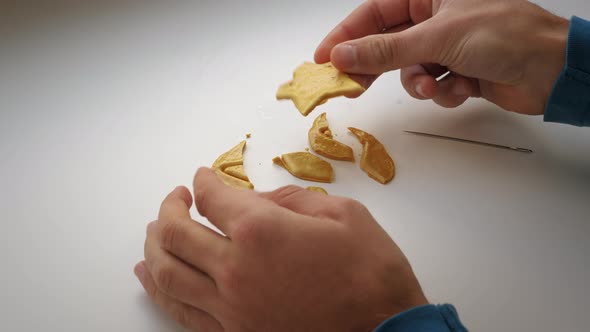 Hands break Dalgona candy cookies. Broken brown sugar caramel candy cookies