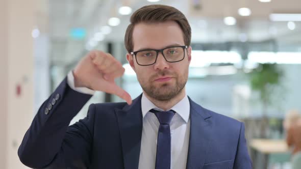 Portrait of Businessman with Thumbs Down Gesture