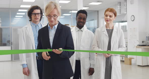 Mature Businesswoman Cutting Ribbon Opening New Biochemical Laboratory