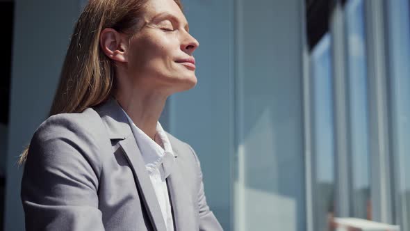 Satisfied Business Woman Dressed in Classic Suit Meditate in Lotus Position