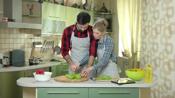 Man and Woman Cutting Lettuce