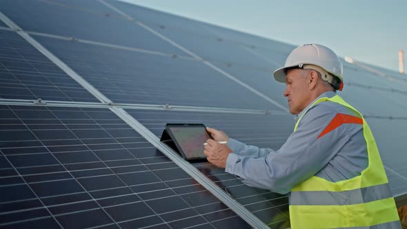 Solar Engineer Working with Digital Tablet at Renewable Energy Farm