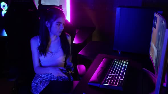 Young Woman Playing an Online Game in Neon Gaming Club