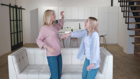 Happy Family Senior Mom Having Fun with Adult Daughter Dancing in Living Room Carefree Old Mother