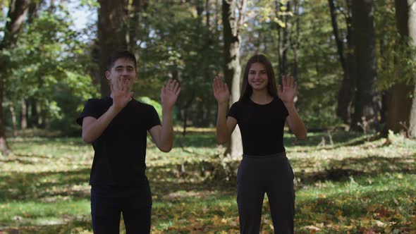 MS Boy and Girl Jumping and Throwing Dry Leaves in Park