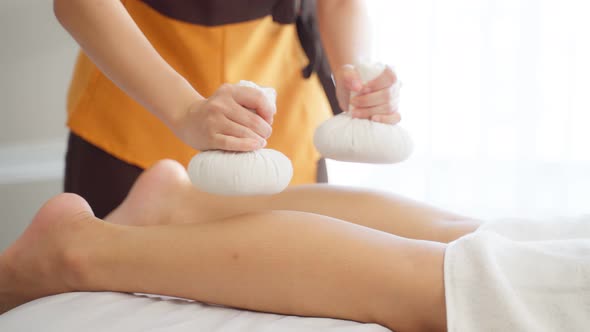 Close up of young girl feel relax during leg massage with herbal bags.