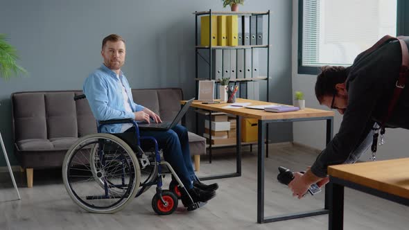 Photographer Taking Photo to Disabled Freelancer with Laptop Sitting in Wheelchair at Office