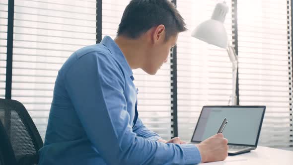 Asian handsome business man using laptop computer working in office.