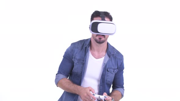 Happy Young Bearded Hipster Man Playing Games and Using Virtual Reality Headset