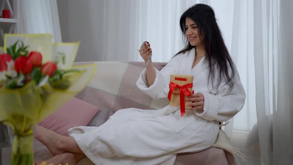 Wide Shot of Happy Middle Eastern Bride Admiring Watch Gift for Future Husband Sitting on