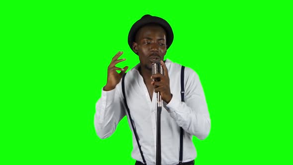 Singer Sings Into a Retro Microphone Spinning and Dancing Around Him. Green Screen