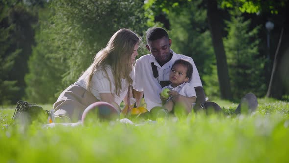 Black Father Fairskinned Mother and Mestizo Child in the Park