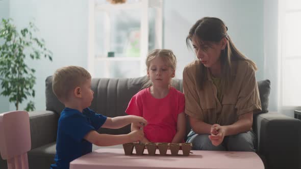 Woman Teaches Children How to Plant Flowers Little Child Makes Holes