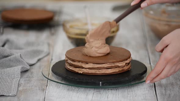 Step by step. Pastry chef making chocolate layer cake with prune filling