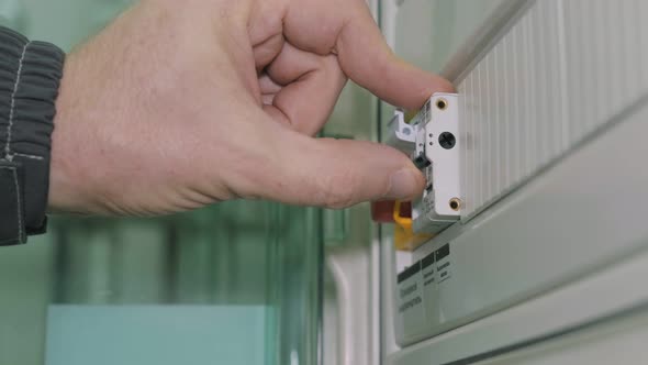 Person Flicking a Switch on and Off in the Electrical Cabinet.