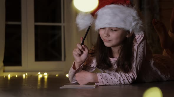 Christmas Moment. A Charming Little Girl Is Writing a Letter To Santa Claus.