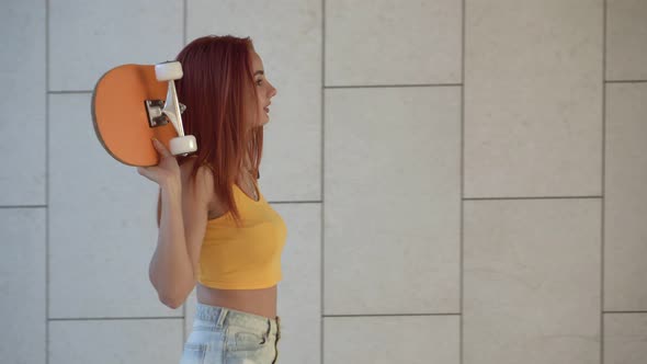 Portrait a Female Student with a Skateboard Outdoors