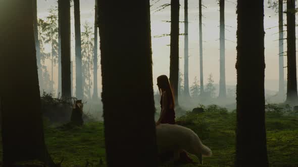 Woman walking in the forest with a dog