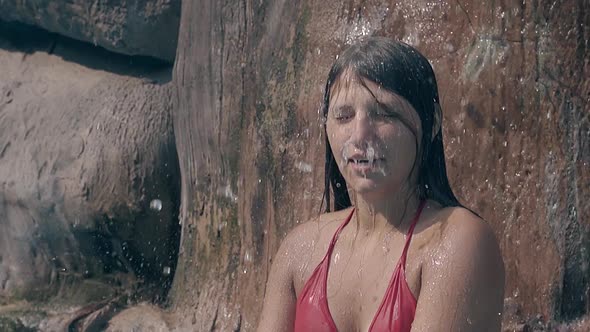 Joyful Girl Under Jets of Waterfall at Rocks Slow Motion